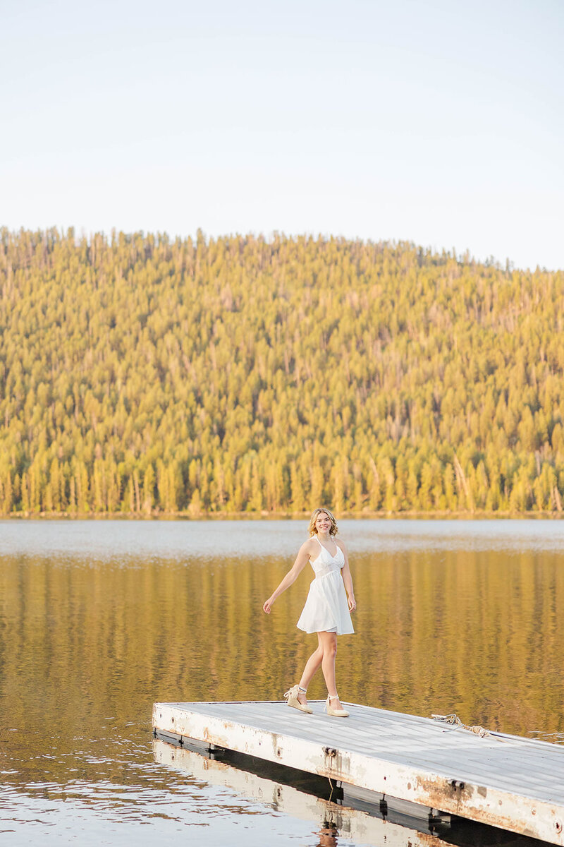 Girl posing on a dock for her senior graduation photos near Pinedale, Wyoming