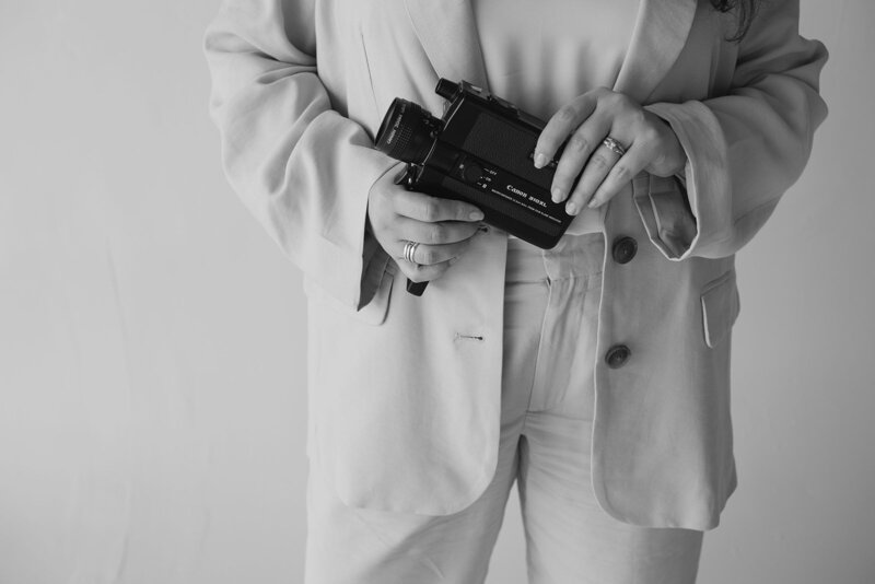Close-up shot of a Super 8 film camera held by a videographer, showcasing the vintage style used by Tyler and Makenzie Films, Florida wedding videographers.