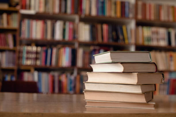 books stacked in front of bookcase
