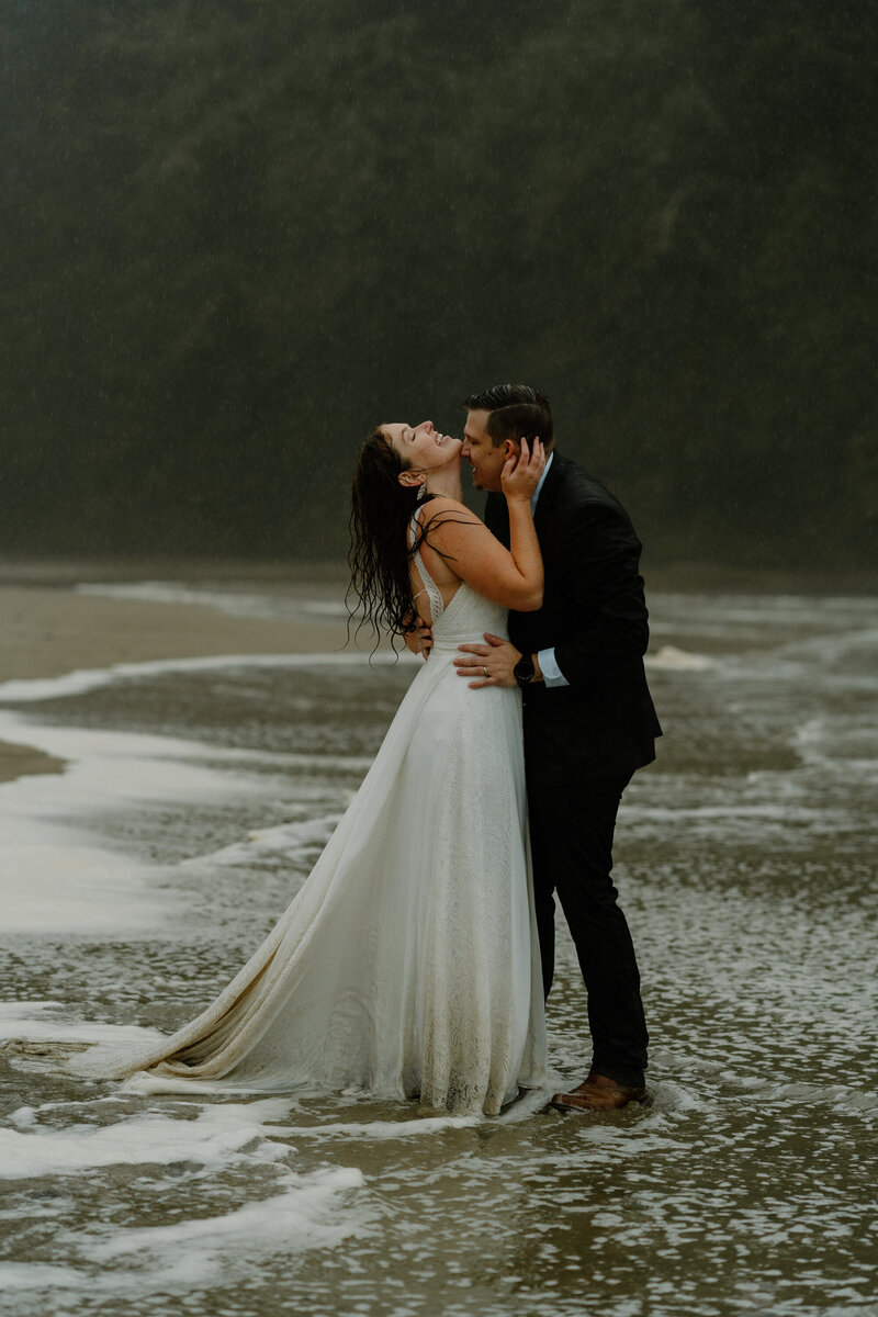 A couple holds hands as they walk together during their elopement on the Oregon Coast