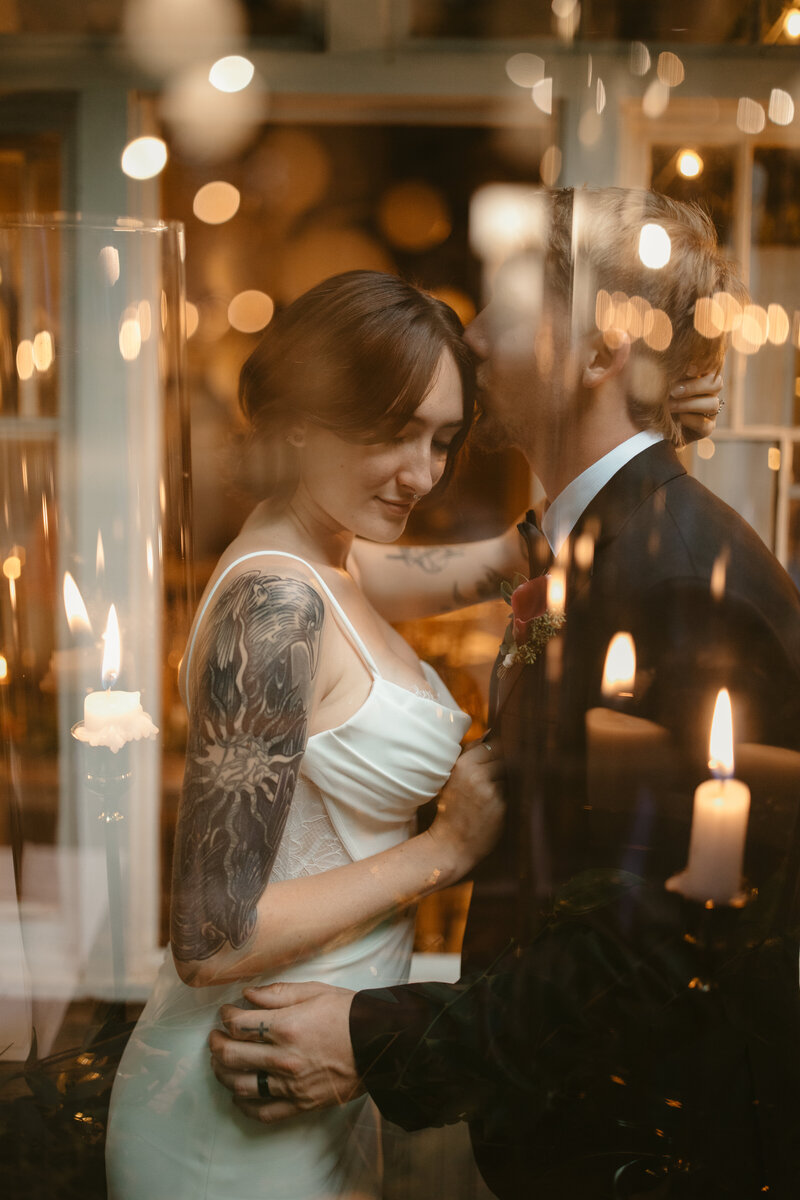 Emotive wedding reception moment captured by Jessica from Rainstorm Photo & Video, featuring a couple sharing a quiet moment surrounded by candlelight.