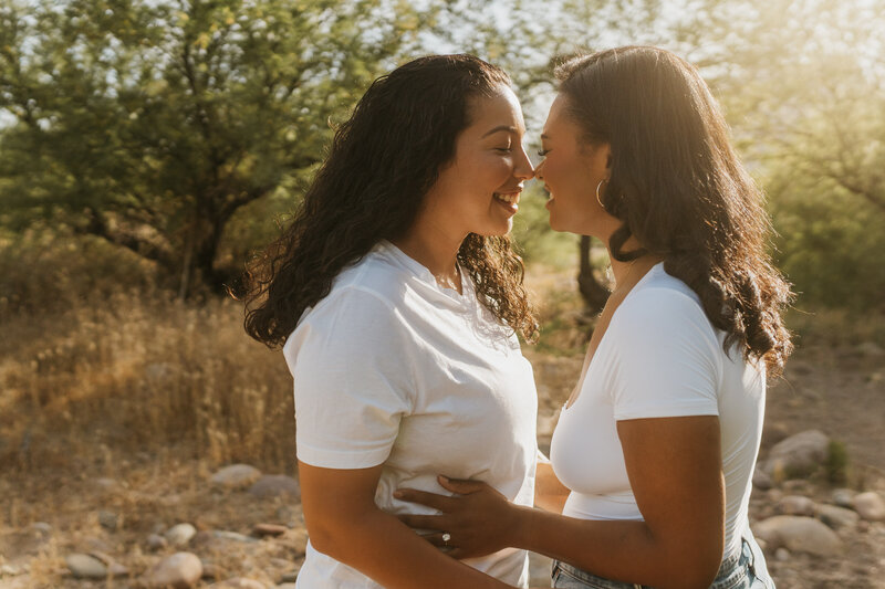 A couple standing close with their arms around each other about to kiss 
