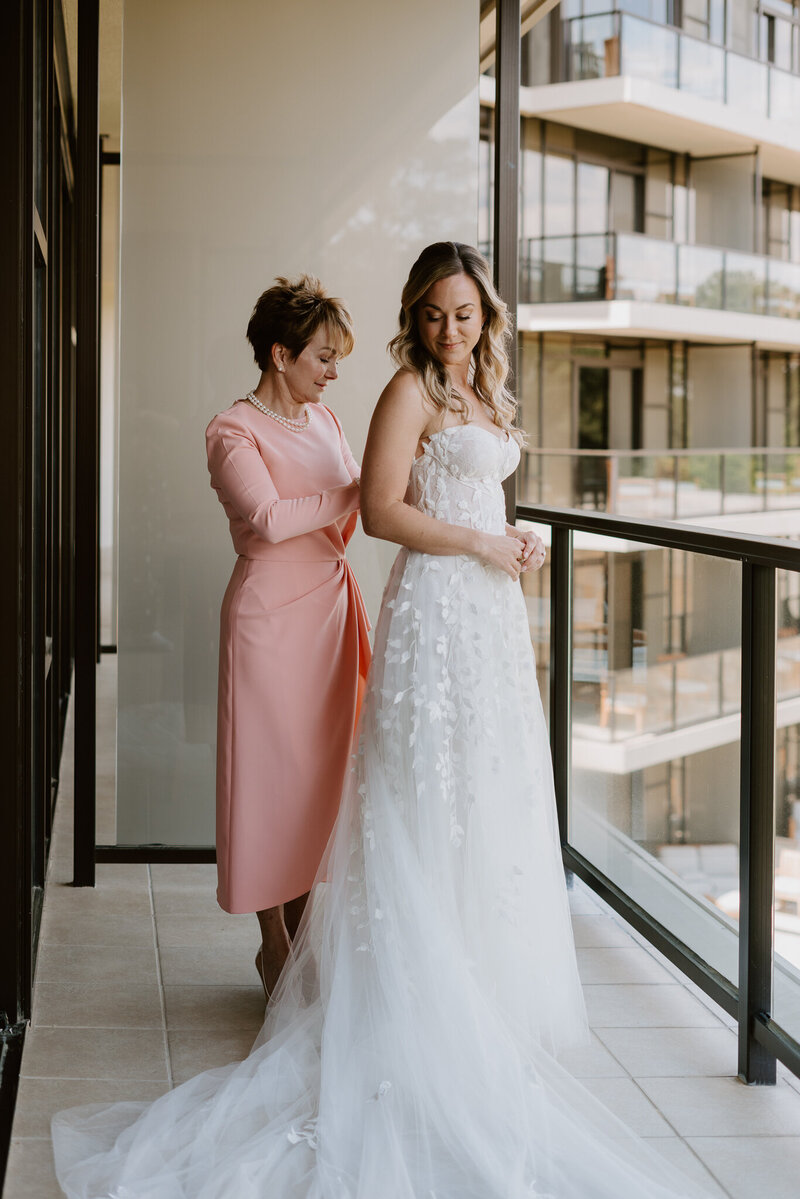 Mother of the bride helping her in dress