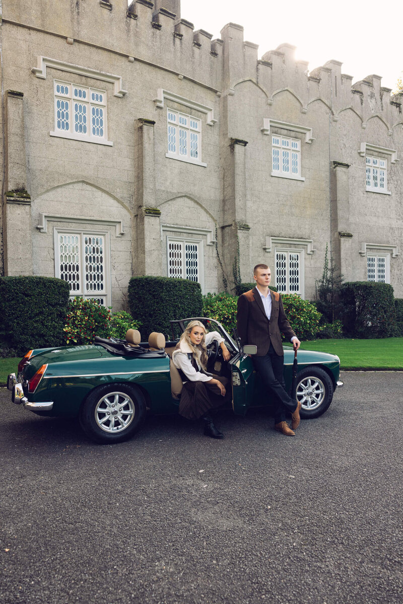 Candid image of a couple posing with a vintage car outside Luttrellstown Castle