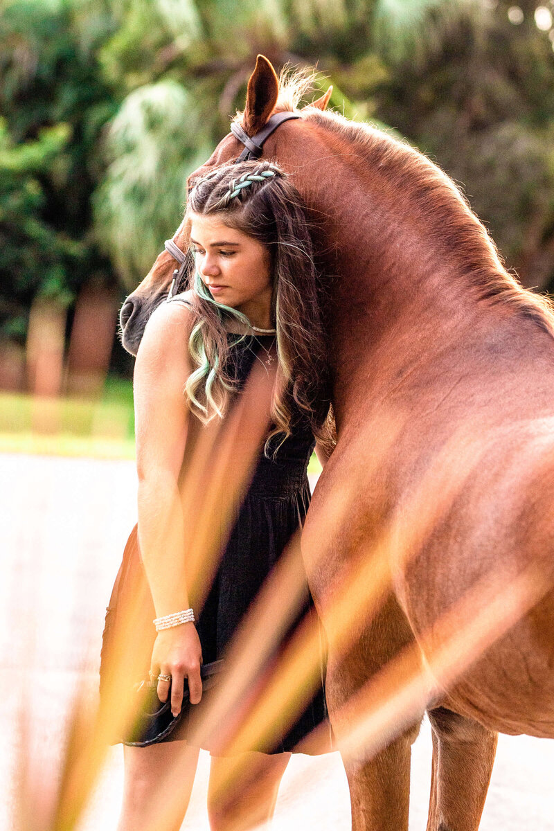 ocala florida equine photography of a girl standing next to her pony during golden hour