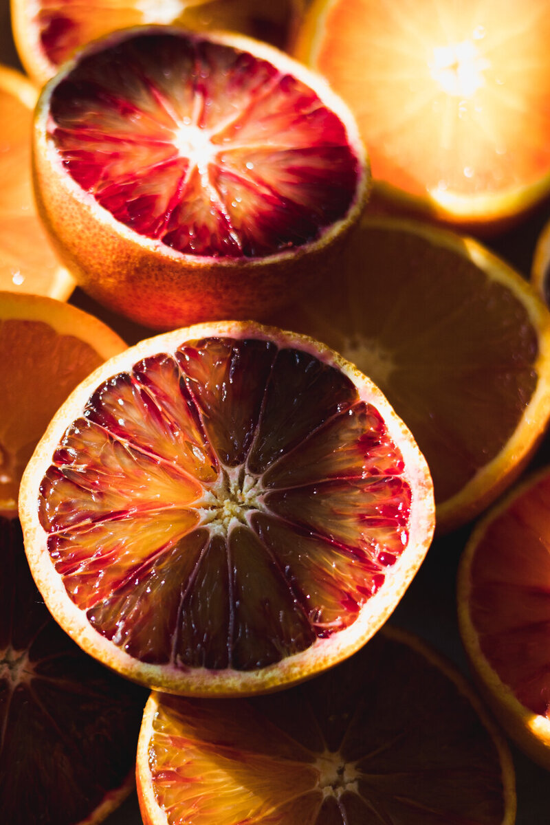 Bloedsinaasappels in zonlicht. Oranje en rode kleuren. Sappig fruit. Foiodfotografie door Dorien Paymans | Studio Ensō Groningen ©