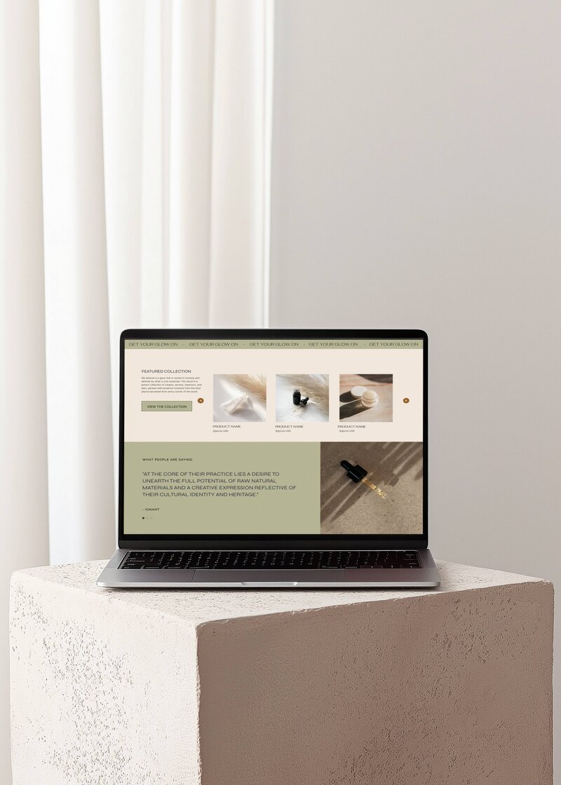 Glory2Glory website showcased on an open Macbook Pro laptop, sitting on top of a stone pillar