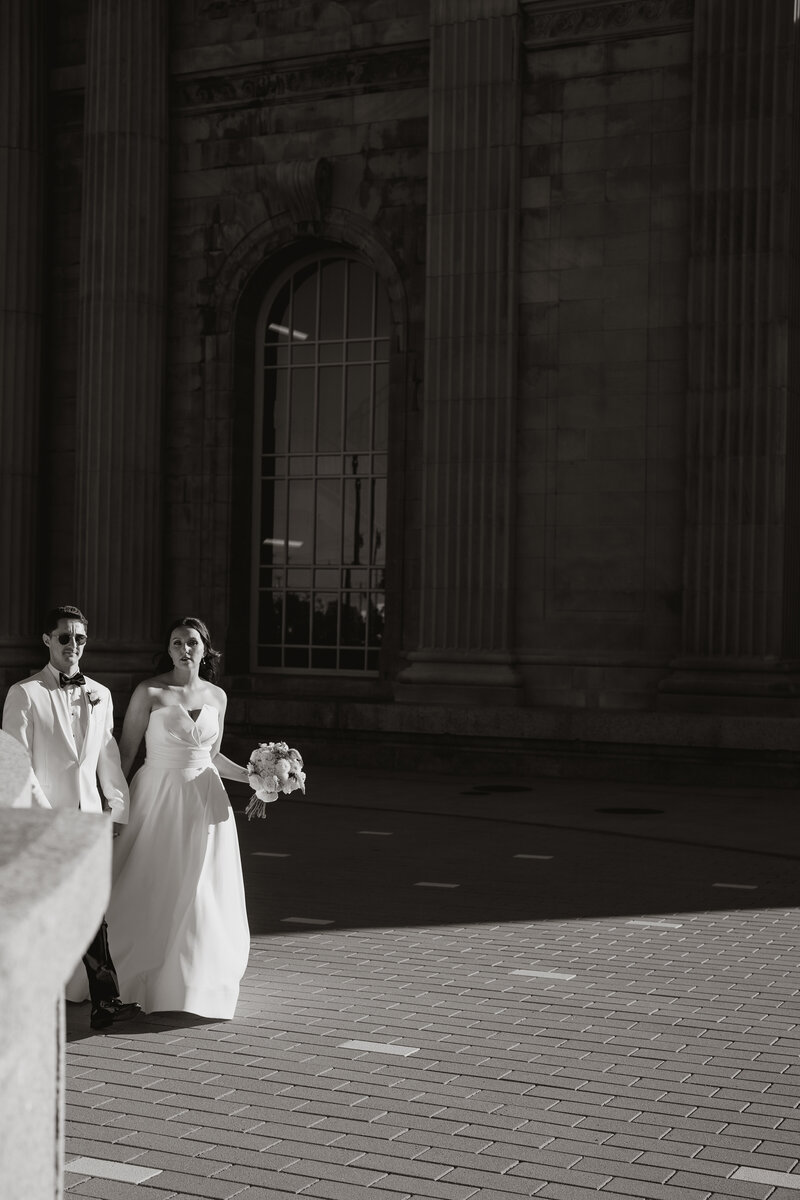 bride and groom walking on the sidewalk