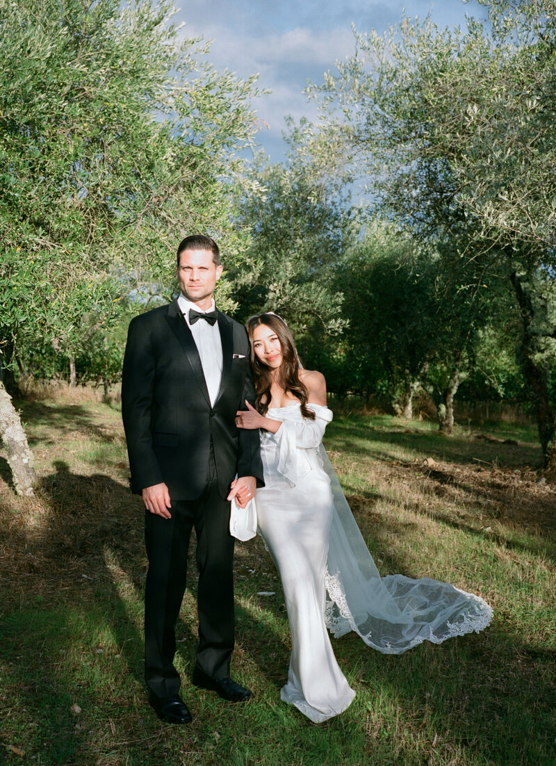 bride and groom posing in olive grove