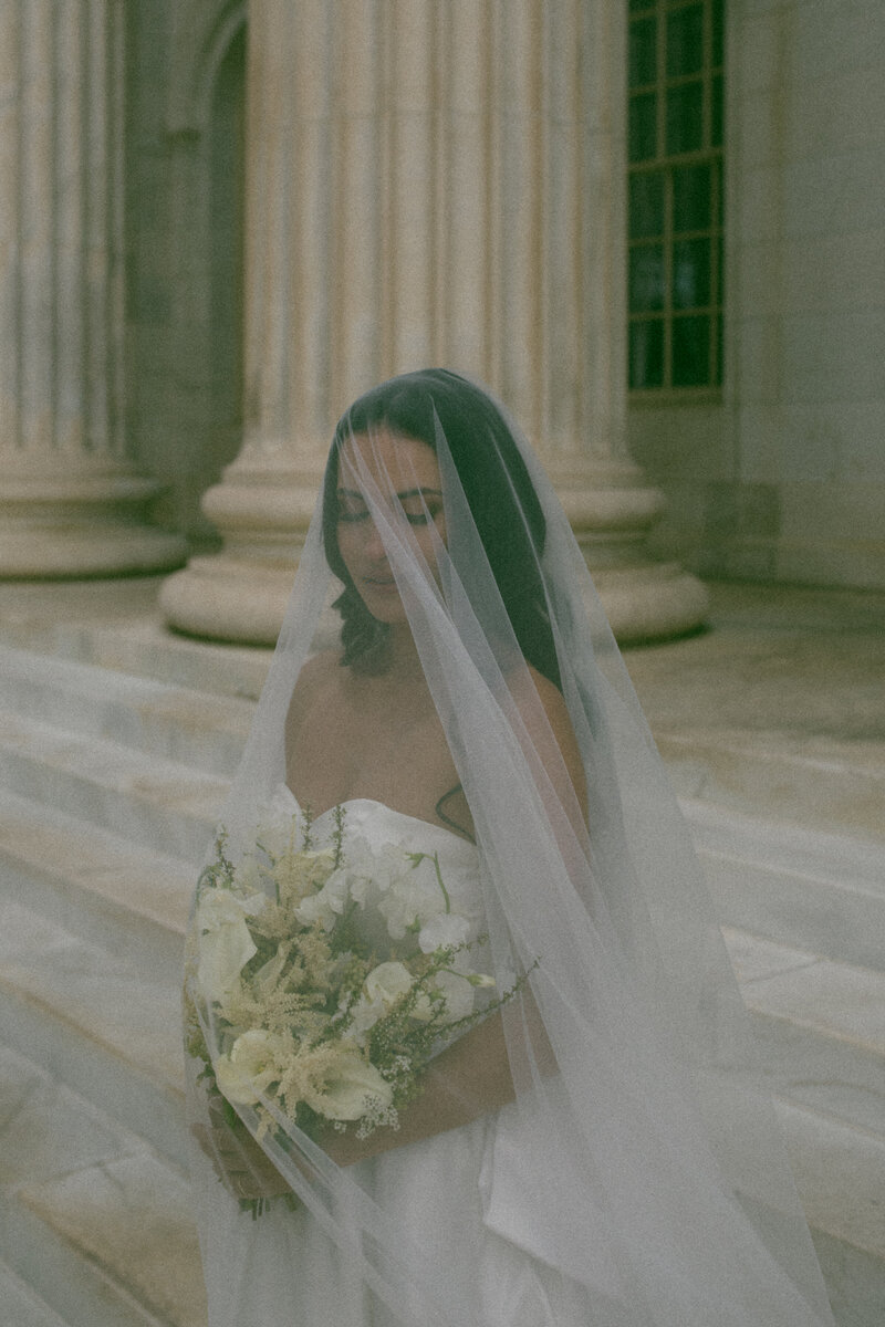 Bride under veil at courthouse