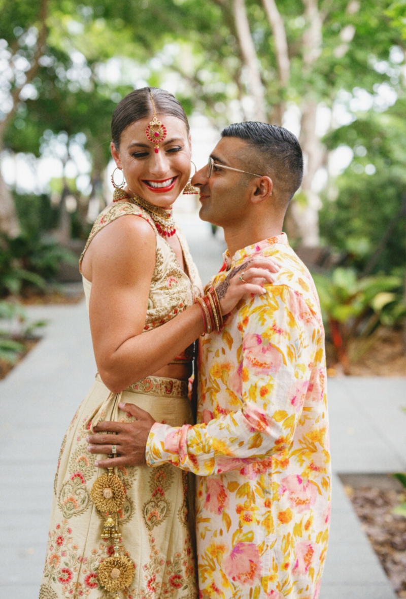 Indian Bride and groom in traditional wedding clothes embracing and smiling outside