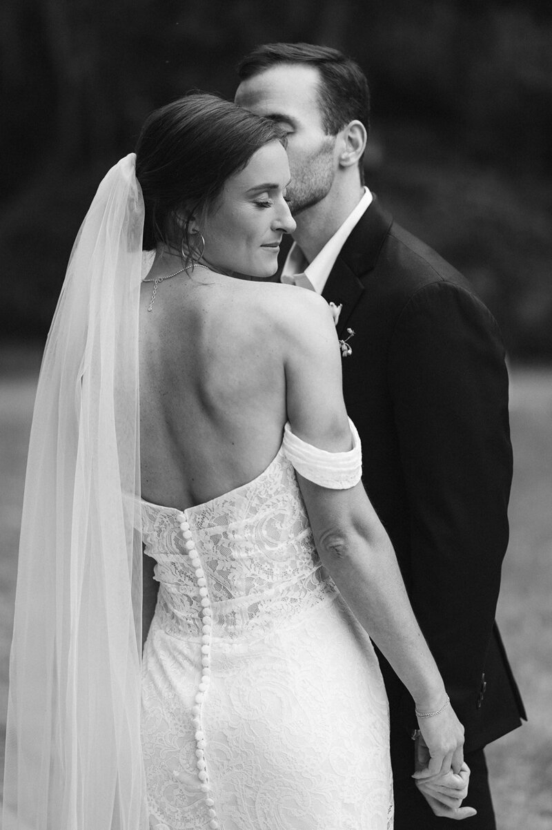 Bride and Groom embrace in a white hall at their wedding venue.
