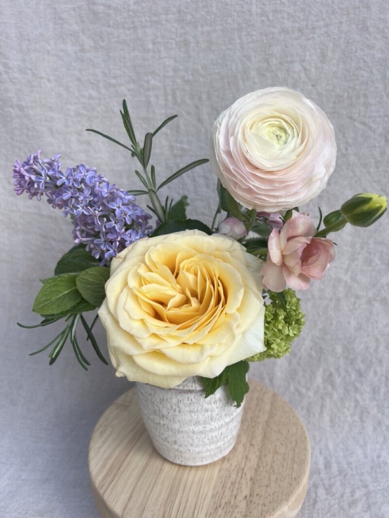 Spring flowers arranged in a petite ceramic bud vase, representing a Mother's day bud vase design by Wild Child Flower Co. 