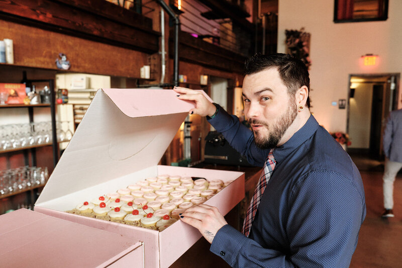 Wedding guest opens up a box of just delivered cupcakes