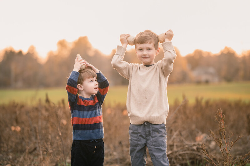 brothers playing with decorative gourds on a boston farm