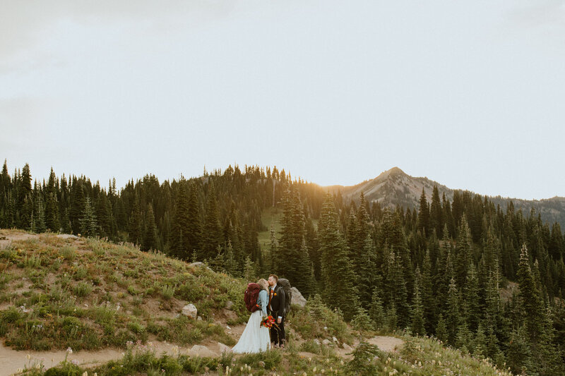 Bride and Groom with their bridal party walking and laughing together in the mountains