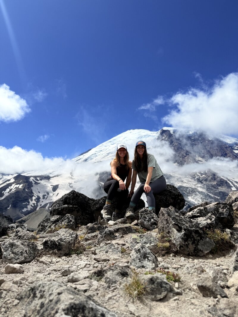 2 women on a mountain after a hike 