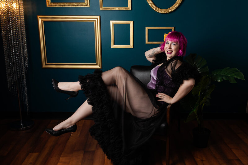 Saint Louis boudoir photographer Boudie City is seated in a chair wearing a black robe