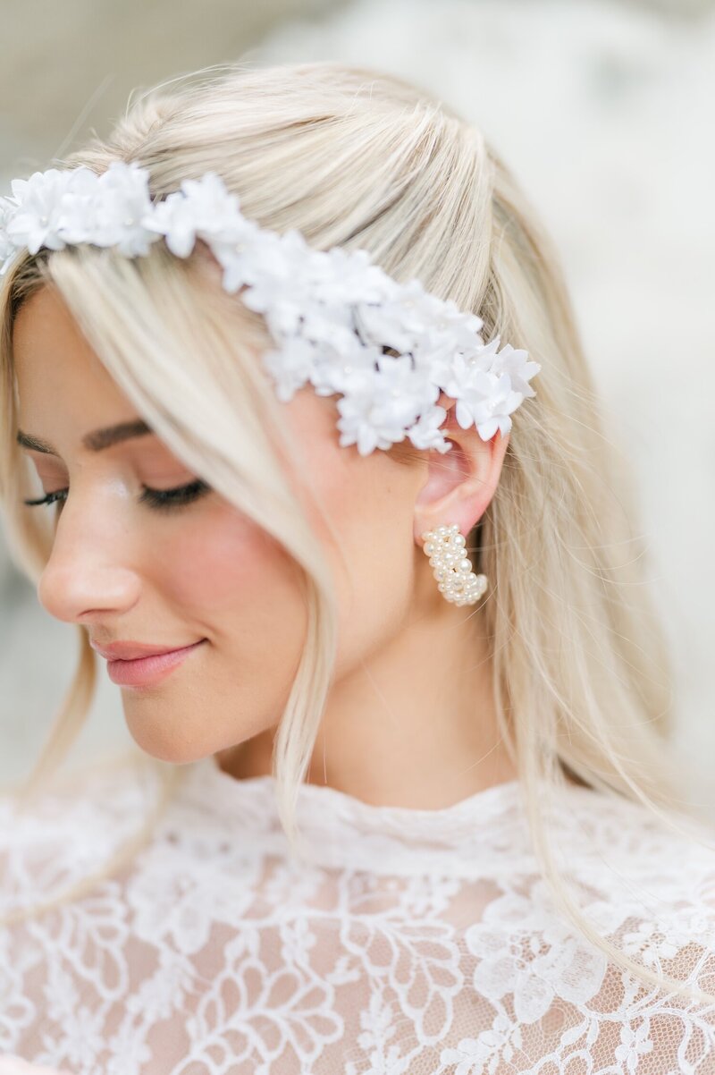 An up close detail photo of a bride's pearl hoop earring. 