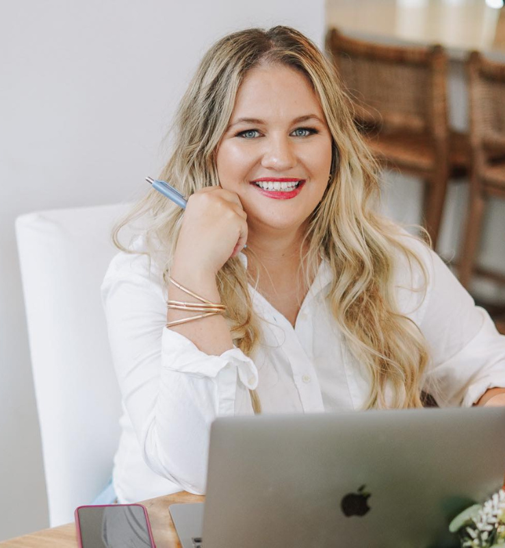 Brandi Mowles sitting in front of laptop smiling