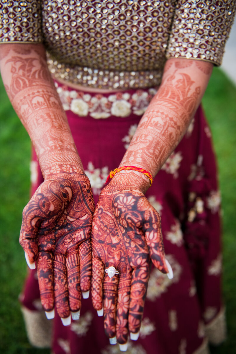 An Indian bride holds out her hands of henna, captured by  Denver wedding photographer, Casey Van Horn.