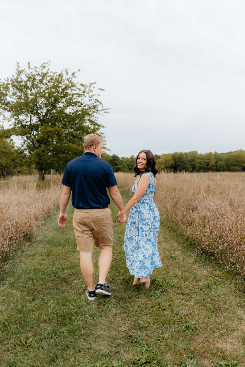 Midwest couples photoshoot in an open field captured by a Michigan and Ohio engagement photographer—perfect for laid-back, nature-loving couples seeking candid and romantic photo sessions in the Great Lakes region.