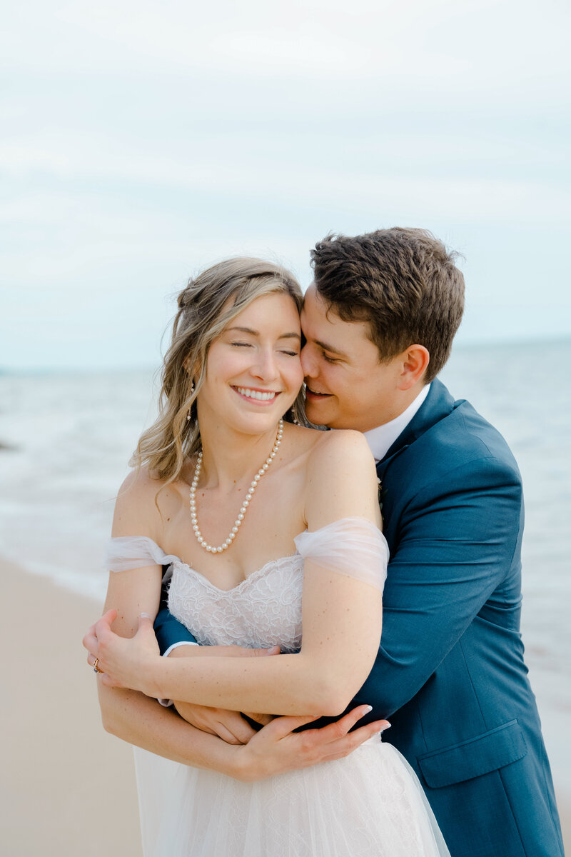 a newly married couple at the beach at Lake Michigan with a Grand Haven wedding photographer