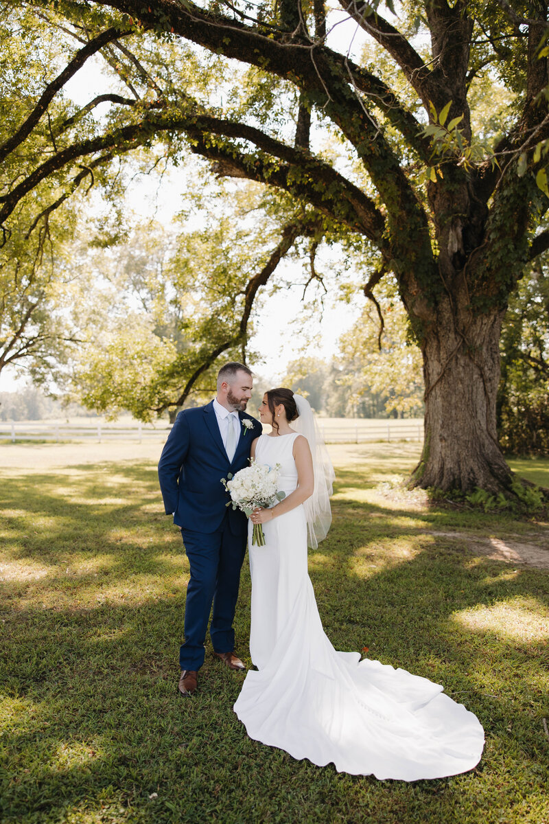 Bride and groom posing under a big tree in Mississippi 