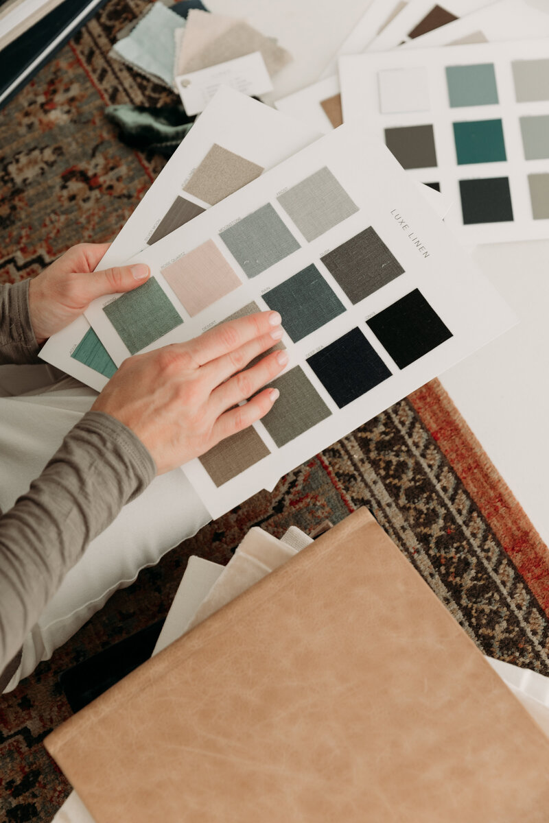 photographer looks through linen fabric swatches for a photo album cover