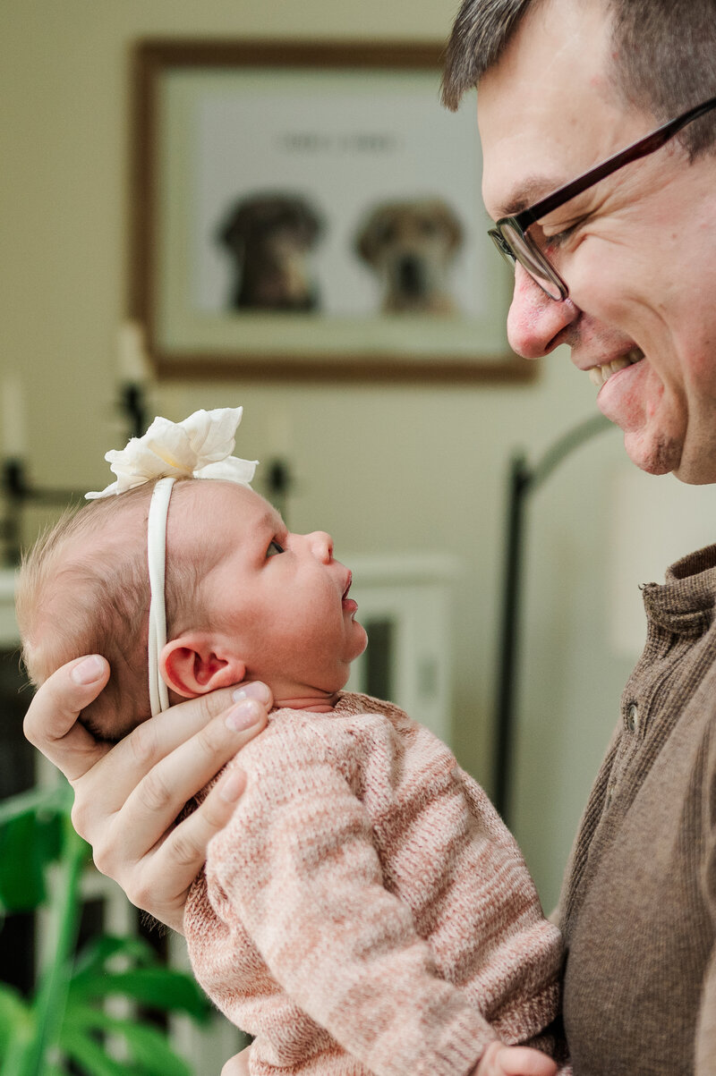 father looking at daughter by newborn photographer baltimore md