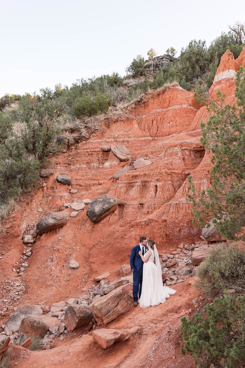 Texas elopement at Palo Duro Canyon State Park featuring bride and groom with red rock cliffs, dramatic canyon backdrops, and golden hour desert light