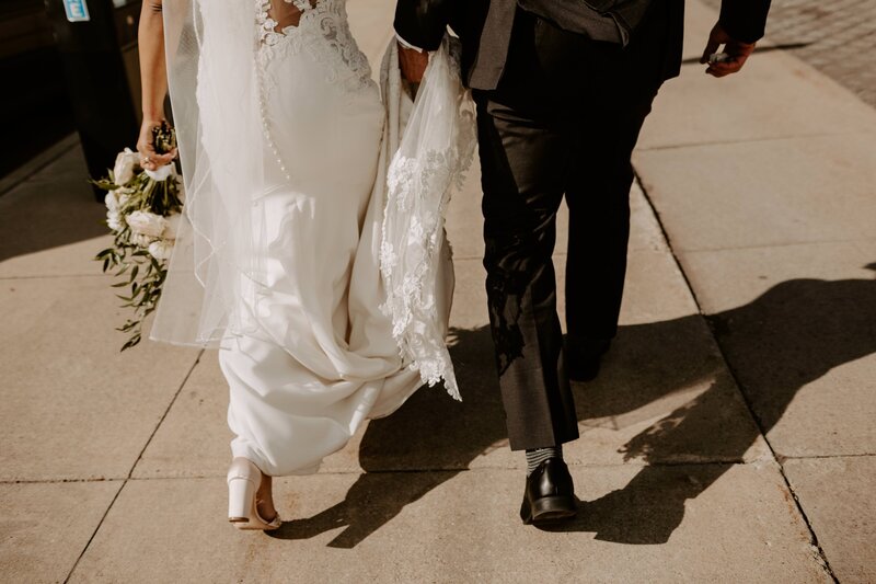 bride and groom walking on the sidewalk