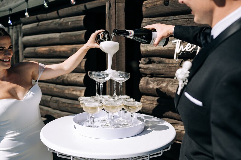 bride and groom pour a champagne tower at their christchurch backyard wedding