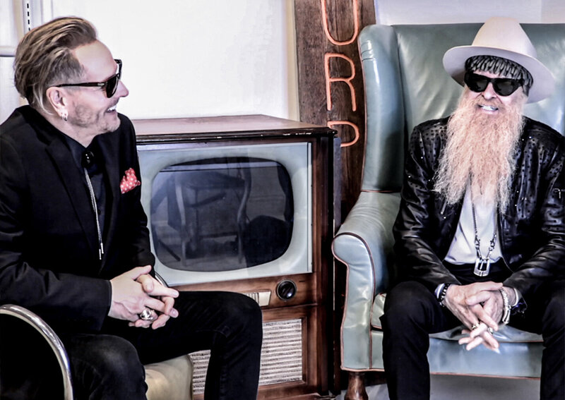 The Art of Giving Webisode One Matt Sorum Billy F Gibbons both of them smiling while seated
