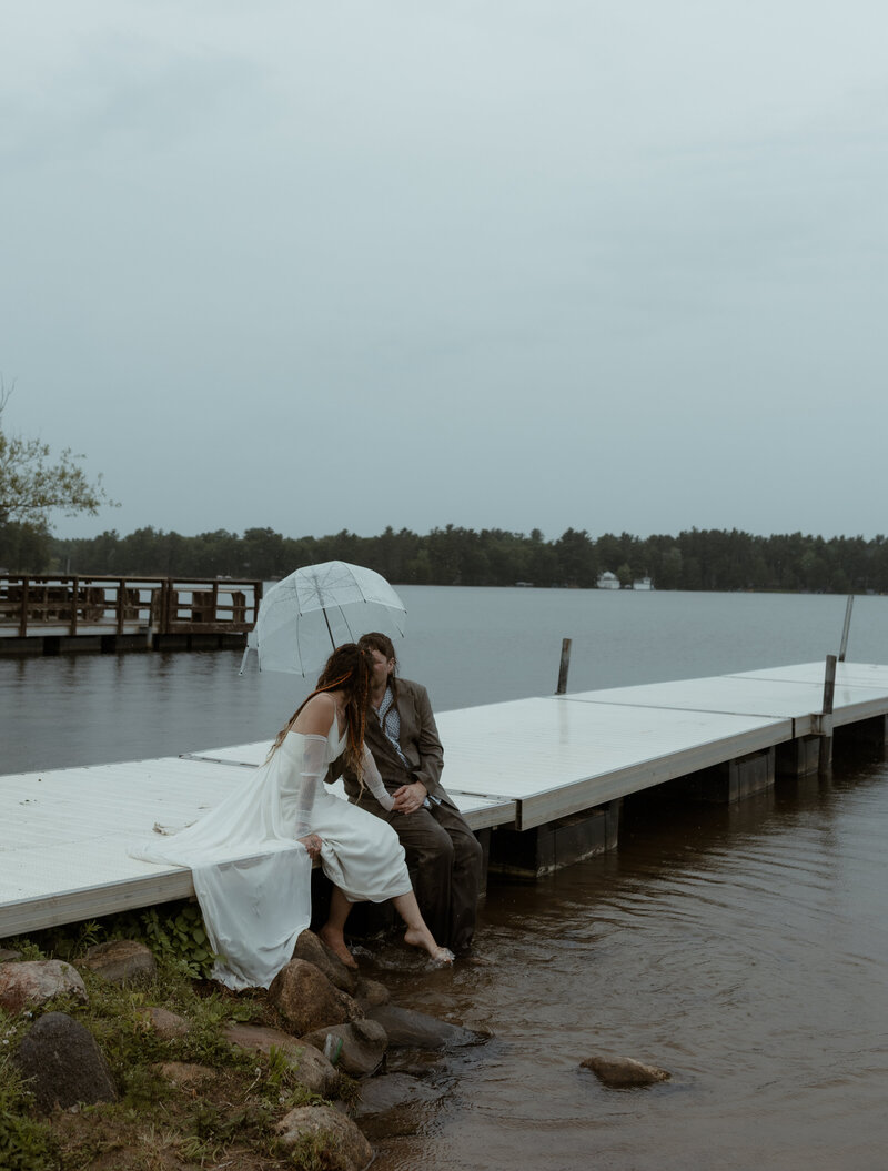 bride in lace wedding dress and groom in suit walking hand-in-hand through a forest trail during a fall adventure elopement