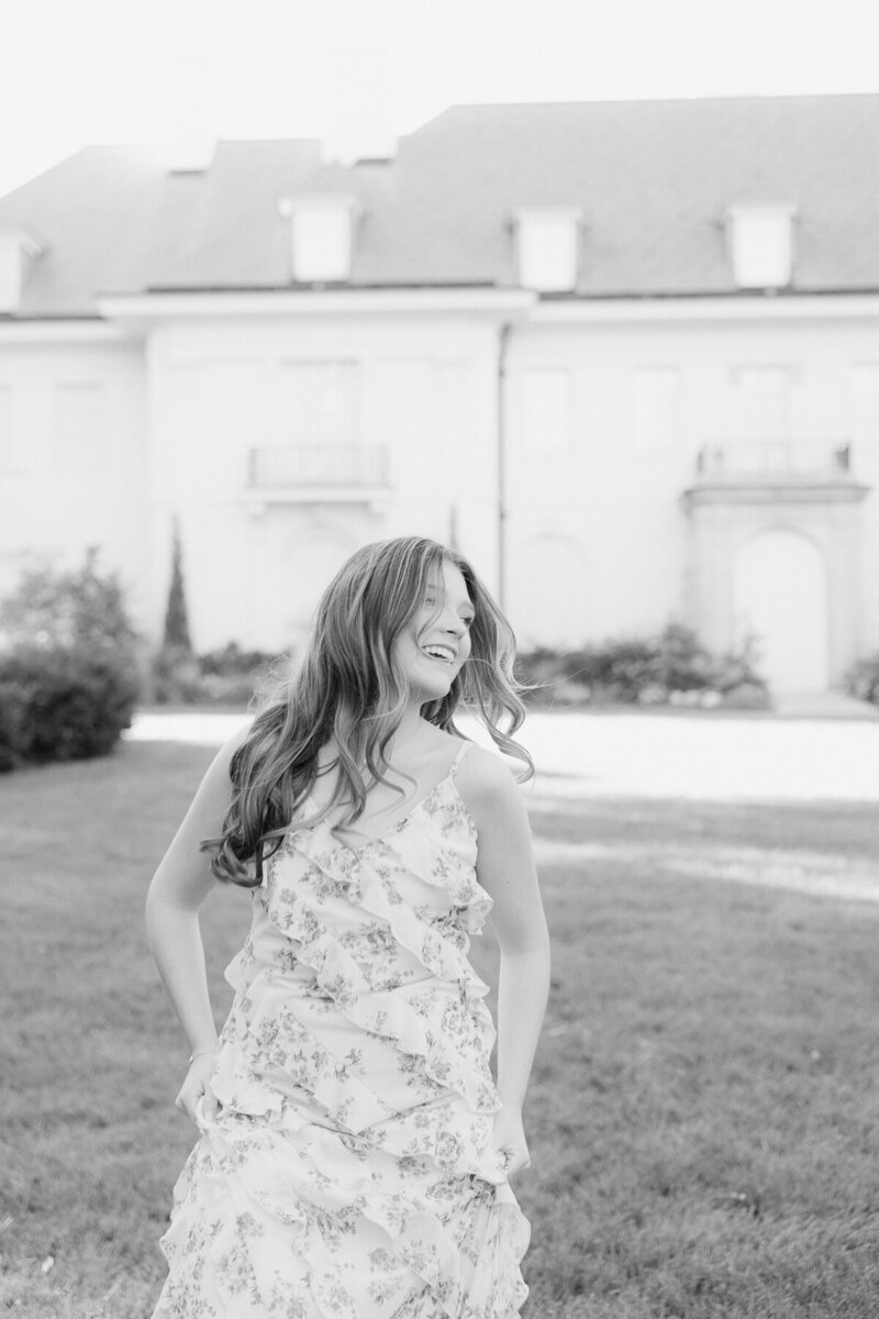 senior girl in floral dress running at at Newfields, Indianapolis senior photographer