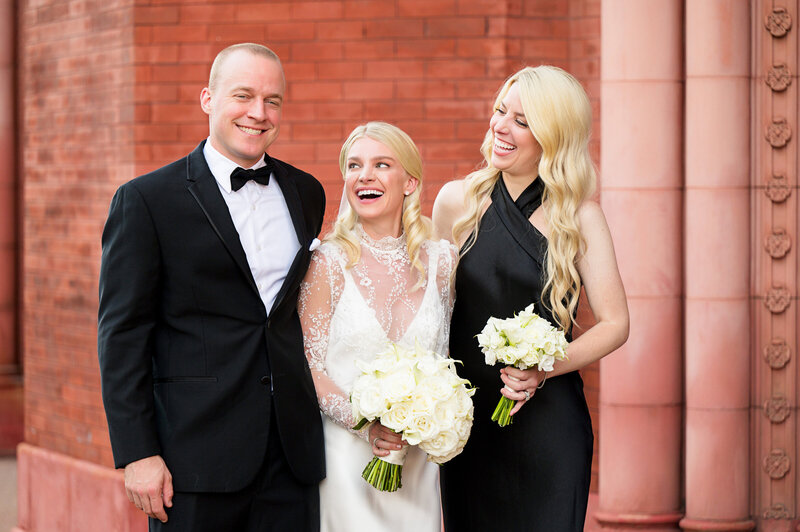 bride and siblings laughing in candid wedding family portrait