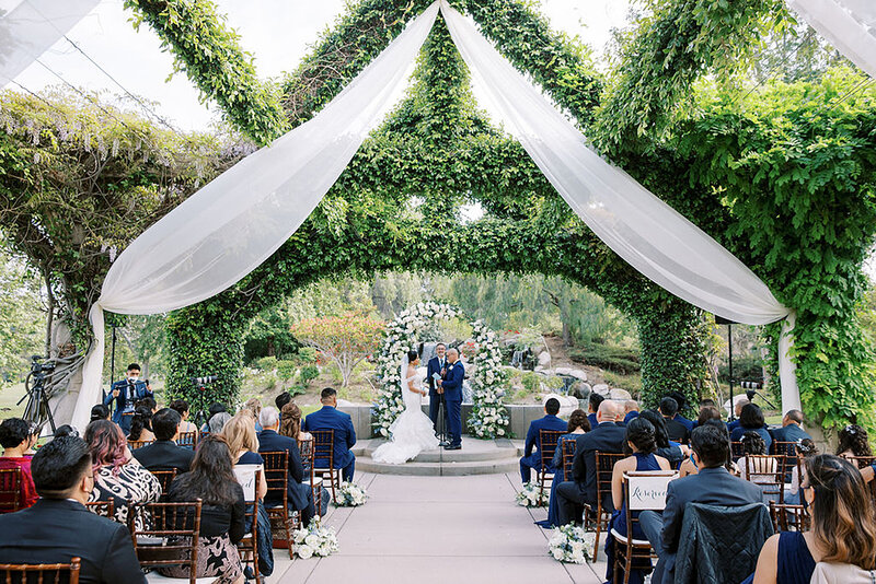 3-radiant-love-event-outdoor-ceremony-high-flowy-white-romantic-drapes-greenery-guests-romantic-elegant-timeless