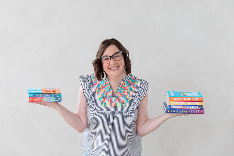 What Sara Reads owner Sara Gillis holding an open book and smiling