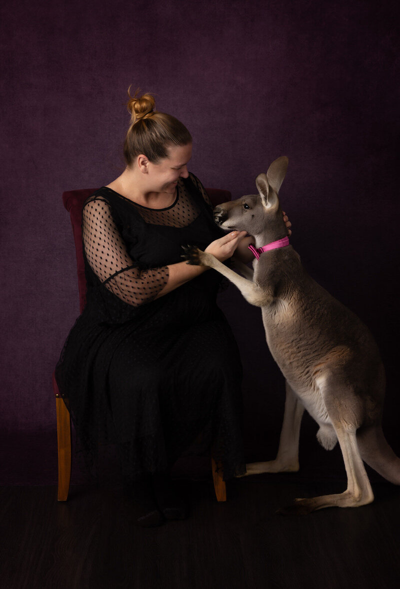 girl-interacting-with-kangaroo-wearing-pink-bowtie