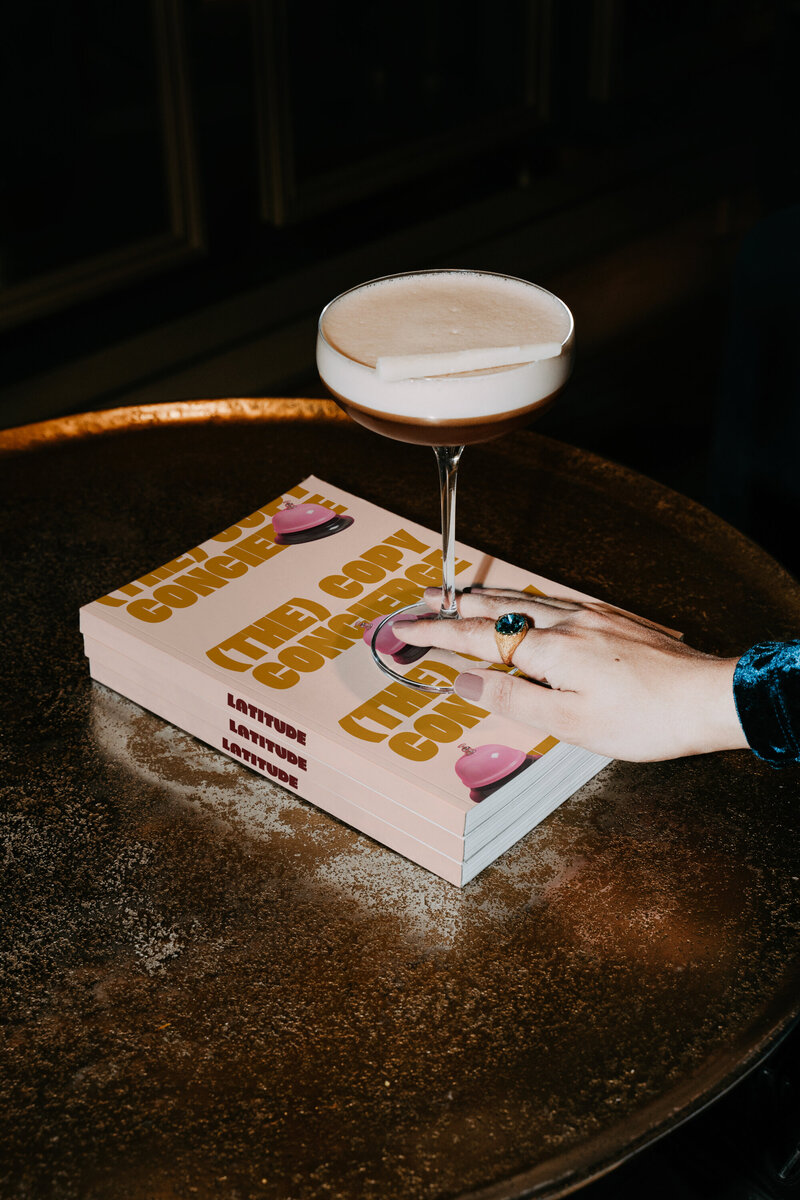 Cocktail sitting on top of a stack of Latitude Lane magazines