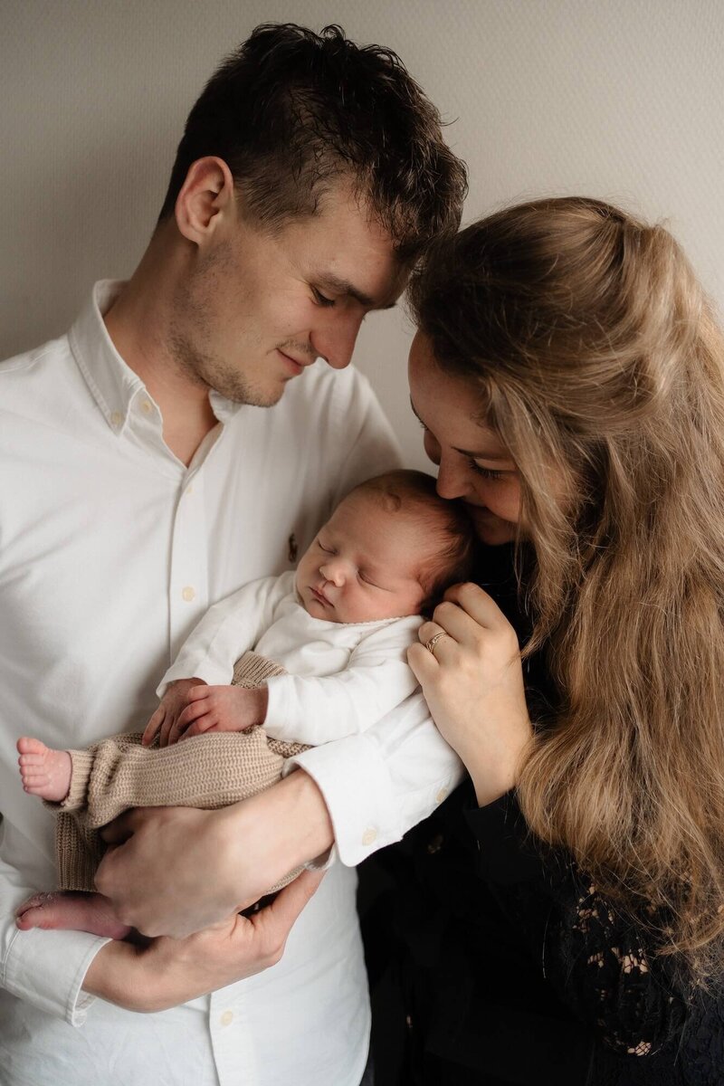 Koppel met baby, vastgelegd door familiefotograaf Julia de Groot tijdens newbornshoot in Utrecht