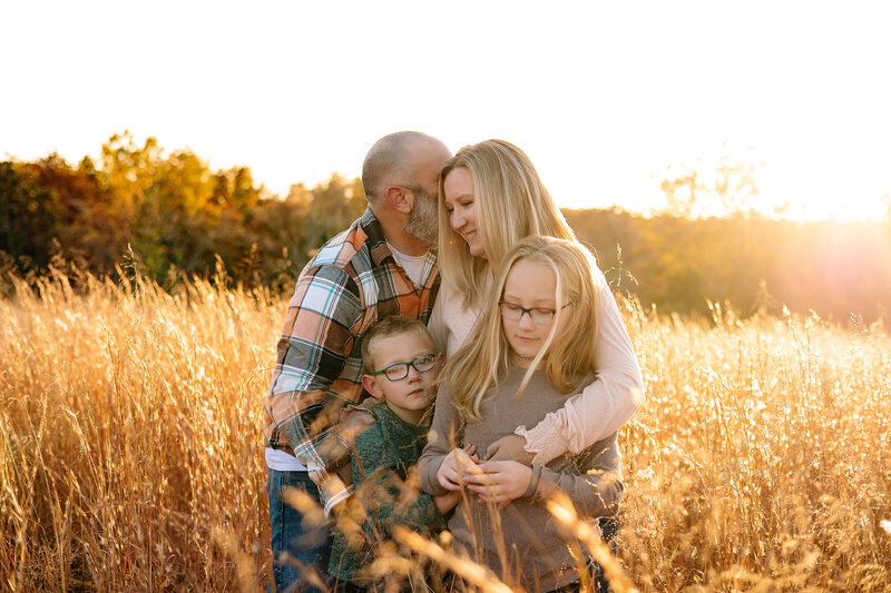 Family portrait taken at sunset on a field. 