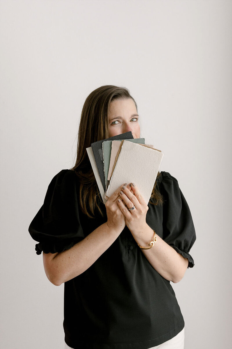 Professional headshot of a woman holding paper