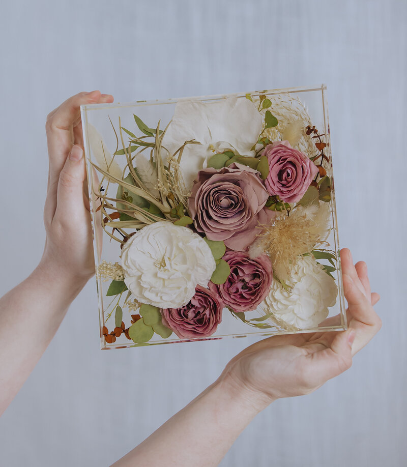Wedding bouquet preserved in a clear resin square. 