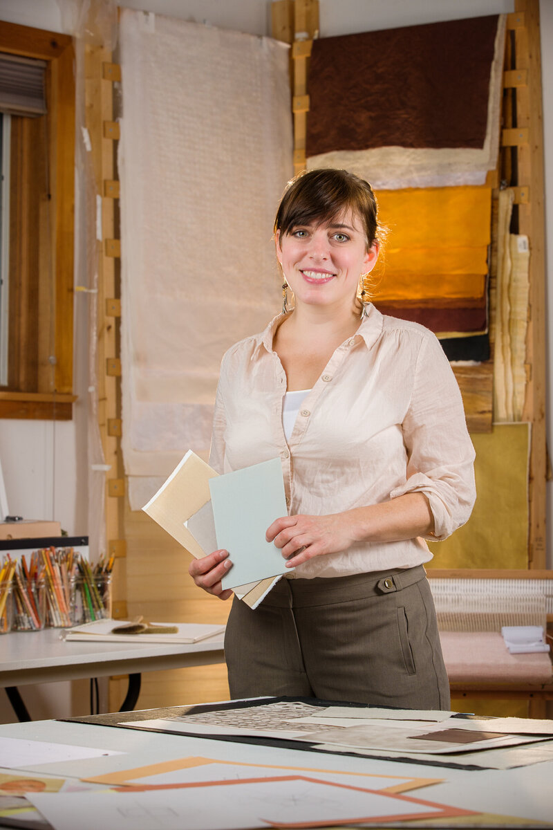 A personal branding sesion of a woman in her art studio holding paper