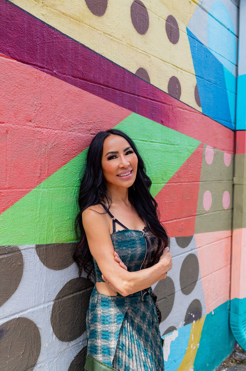 shari leid, leaning up against a colorful mural