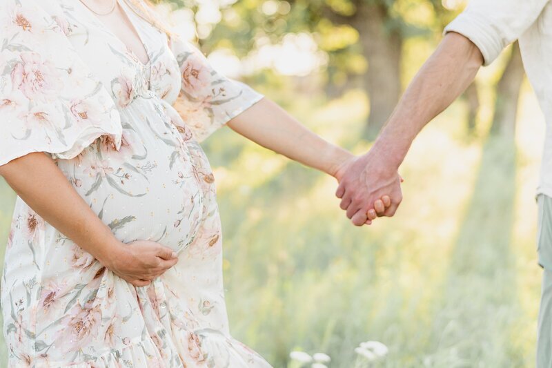 maternity couple close up holding hands
