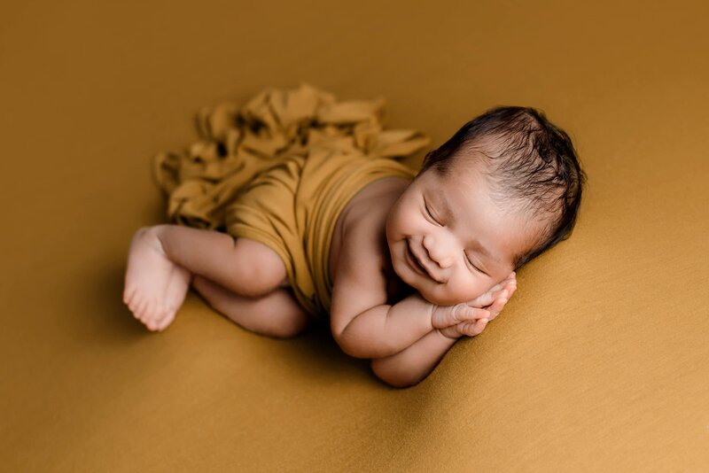 Mustard yellow wrap on newborn boy posed at Vancouver studio newborn session