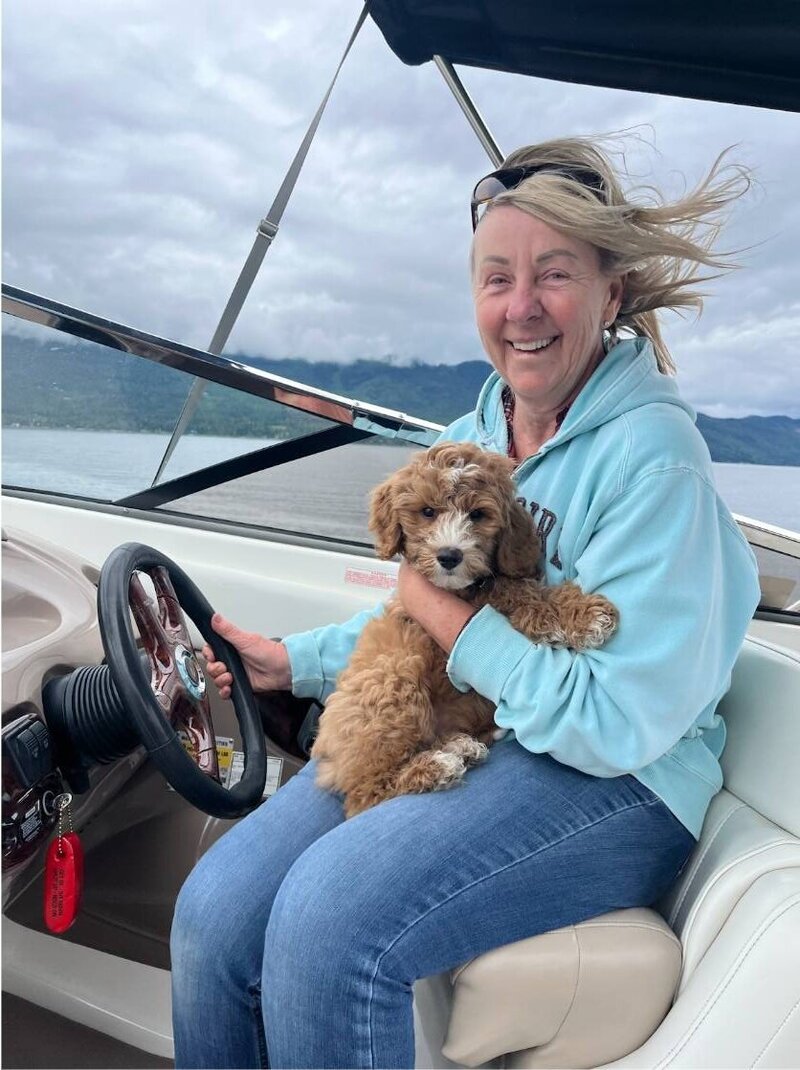 Labradoodle puppy with a woman on a boat